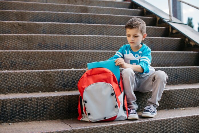 Miserable school boy on his first day of school