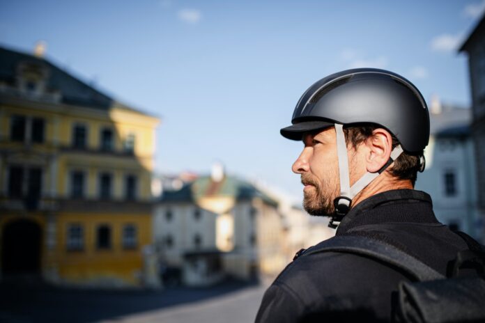 Delivery man courier with bicycle helmet in town