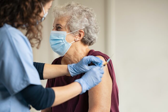 Doctor giving Covid vaccine to senior woman